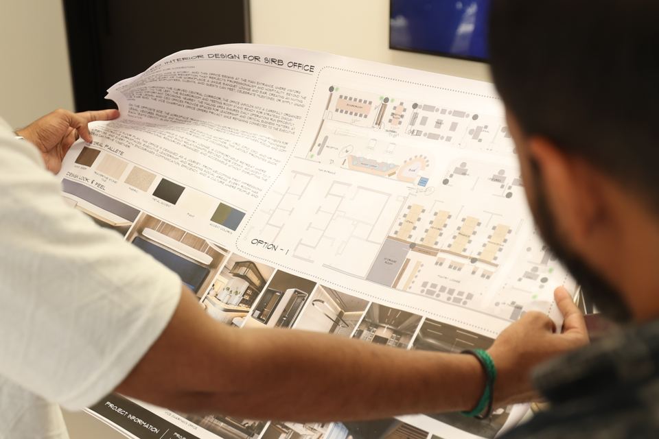 Designers reviewing a printed space plan, option 1
